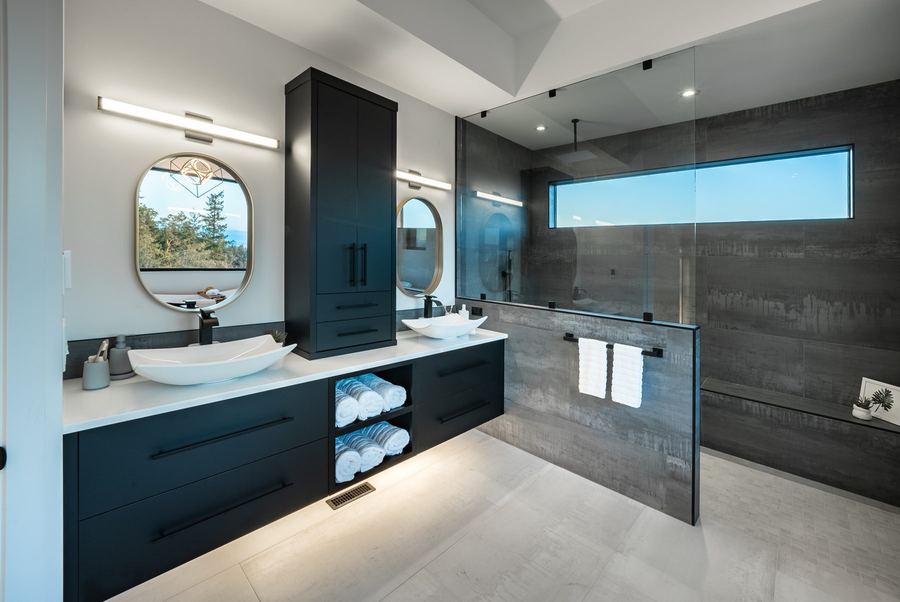Bathroom vanity with vessel sink beside a glass shower