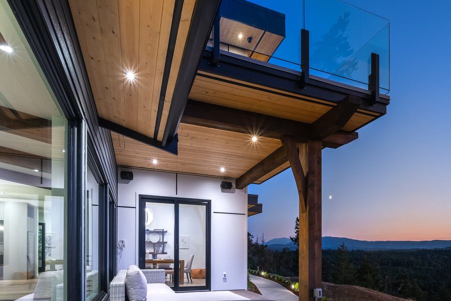 Covered outdoor deck with exposed timber ceiling and glass railing